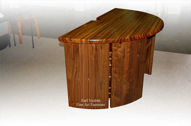 designer desk showing zebrawood top and walnut base with pegs